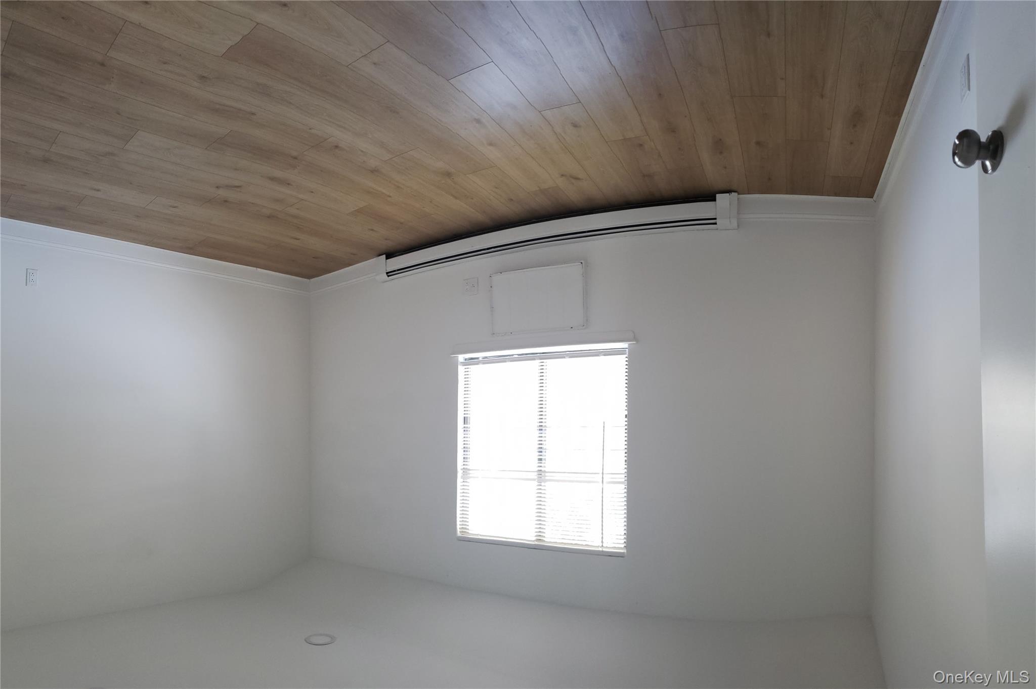 184-11 144th Road Queens, NY 11413 - Photo 5 of 16 an empty room with wooden floor and windows
