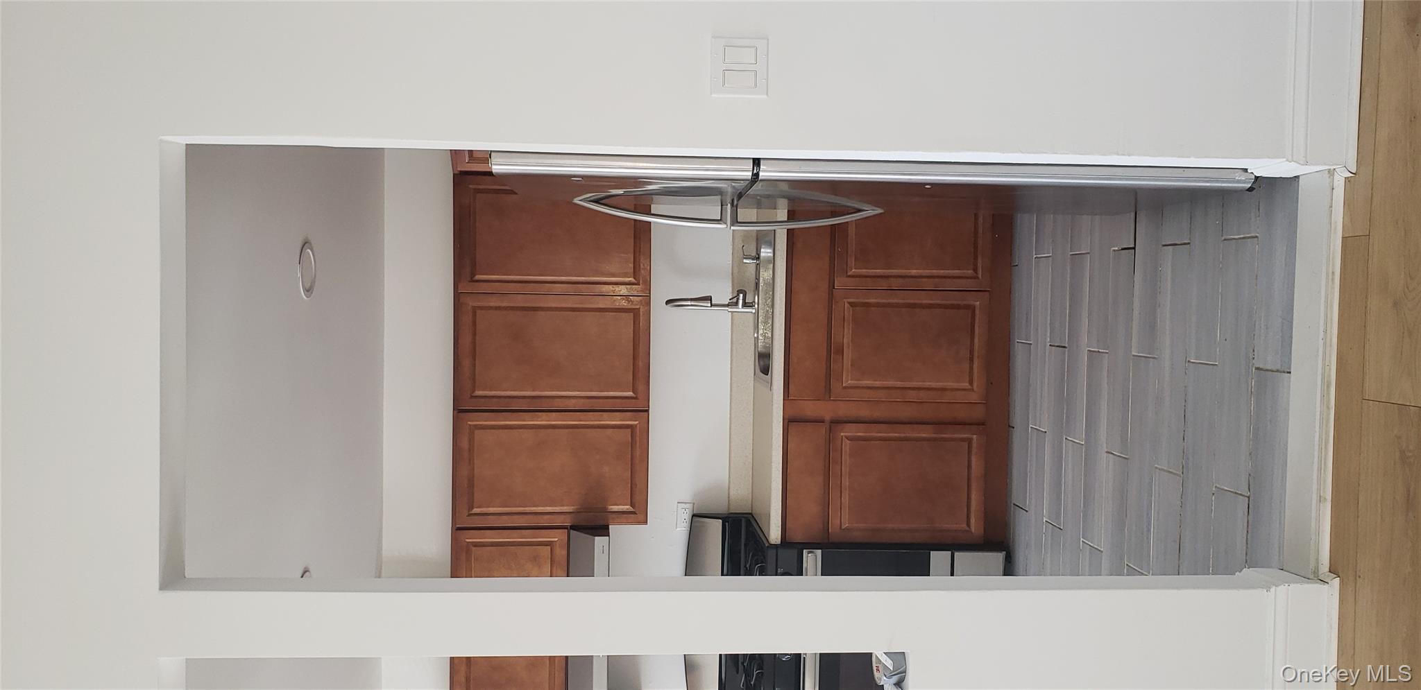 184-11 144th Road Queens, NY 11413 - Photo 7 of 16 a kitchen with a cabinets and white appliances