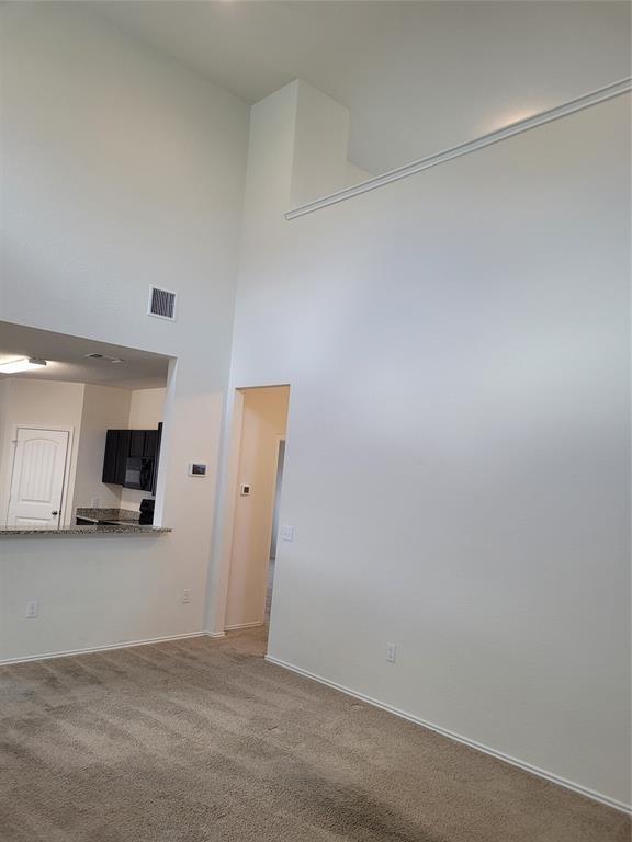 14917 Gypsum Mill Road Manor, TX 78653 - Photo 13 of 28 Voluminous ceilings elevate this living space, offering an airy atmosphere adjacent to the kitchen.