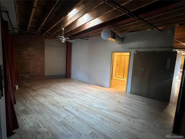 a view of empty room with wooden floor