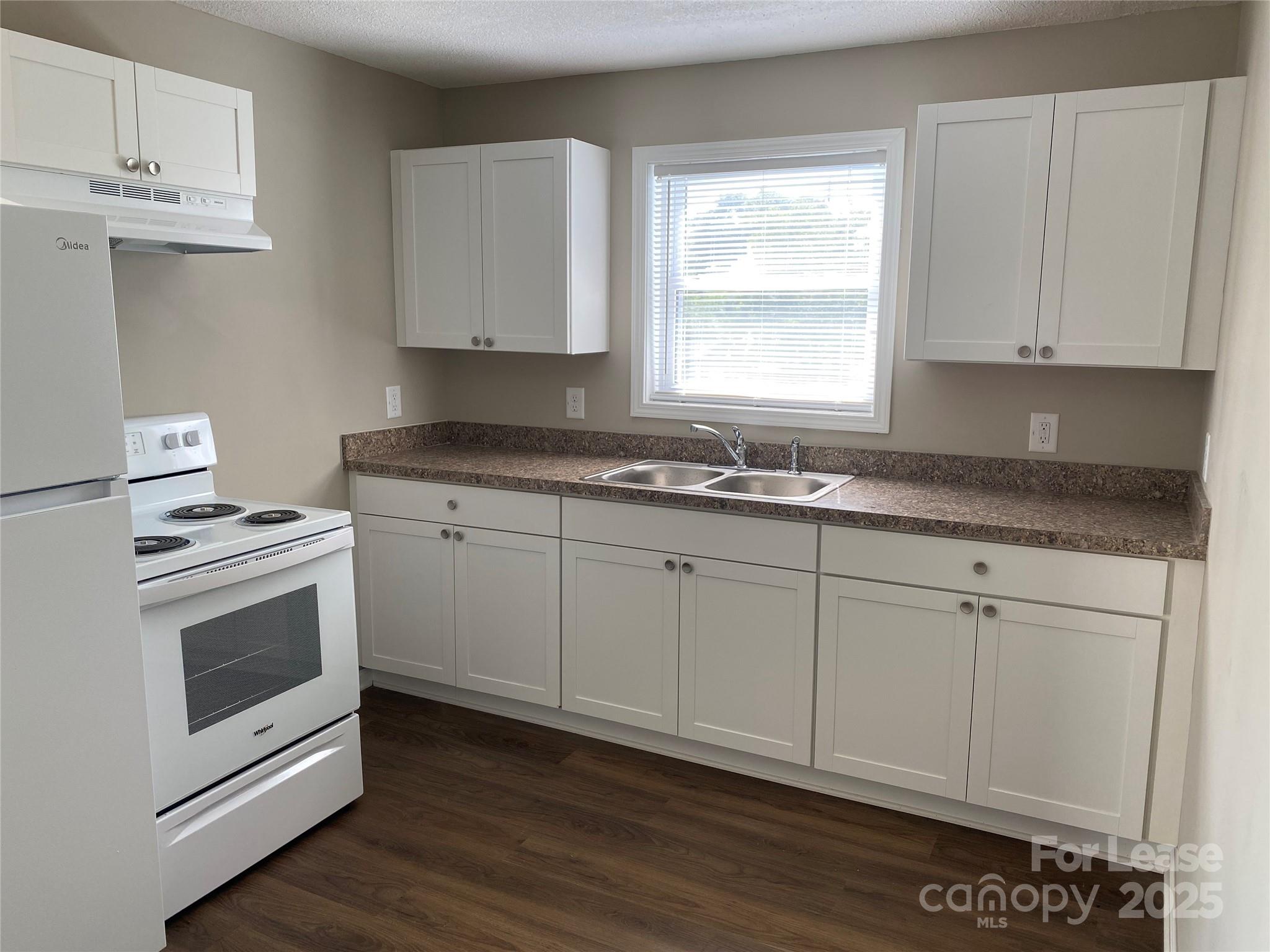 1625 Armstrong Ford Road, Unit B Belmont, NC 28012 - Photo 3 of 5 a kitchen with granite countertop white cabinets and white appliances