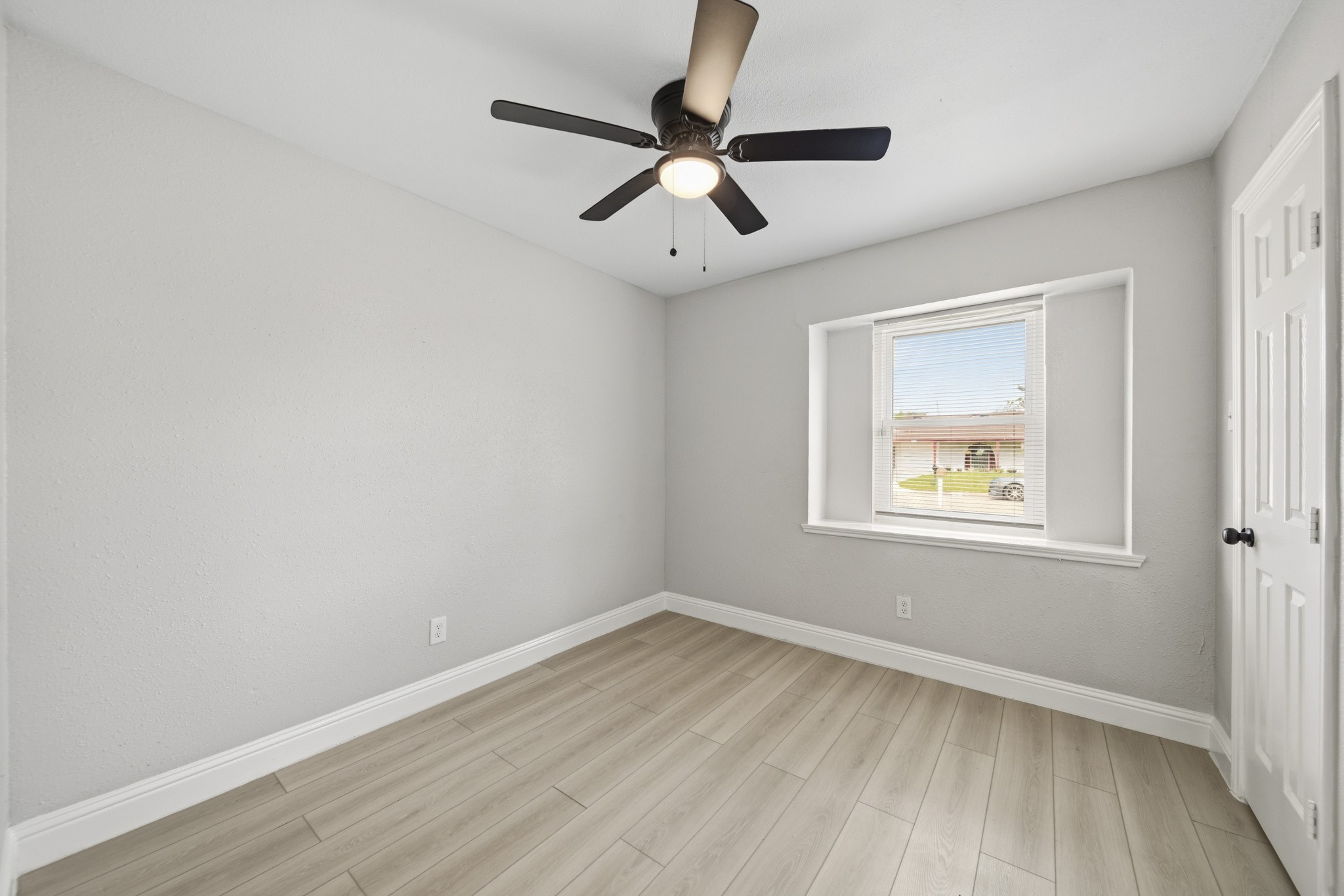 5347 Castlecreek Lane Houston, TX 77053 - Photo 12 of 20 an empty room with wooden floor ceiling fan and windows