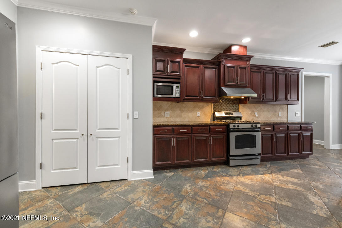 97002 Po Folks Way Yulee, FL 32097 - Photo 13 of 57 a kitchen with stainless steel appliances granite countertop a stove a sink and a refrigerator