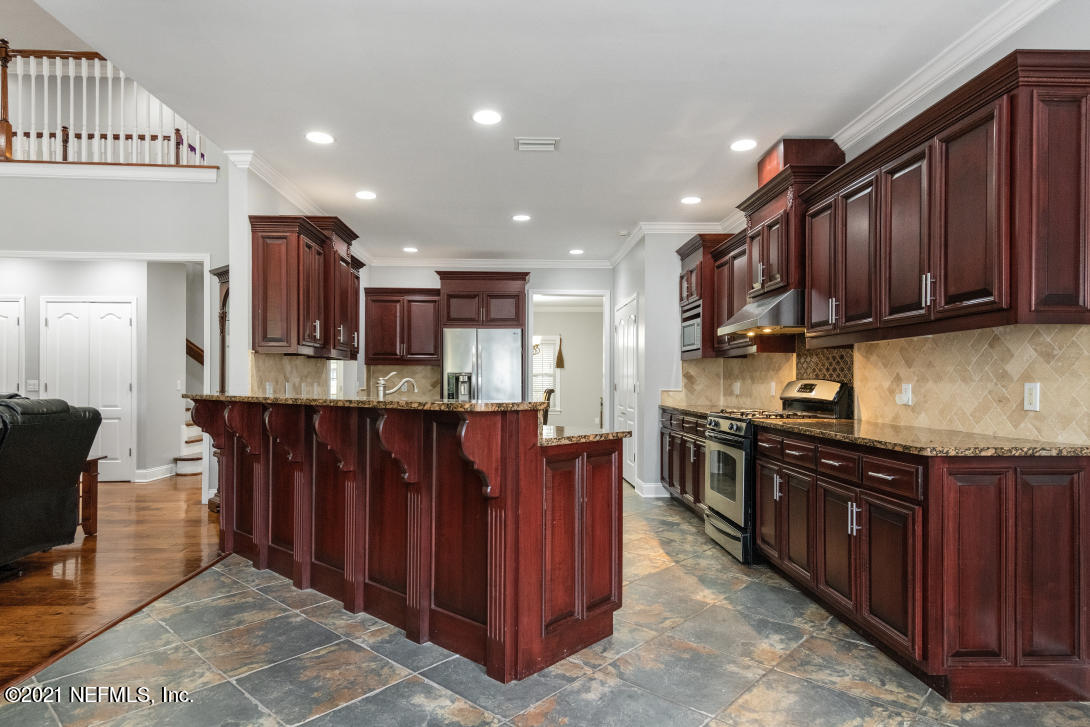 97002 Po Folks Way Yulee, FL 32097 - Photo 14 of 57 a kitchen with stainless steel appliances granite countertop wooden cabinets a refrigerator and a sink