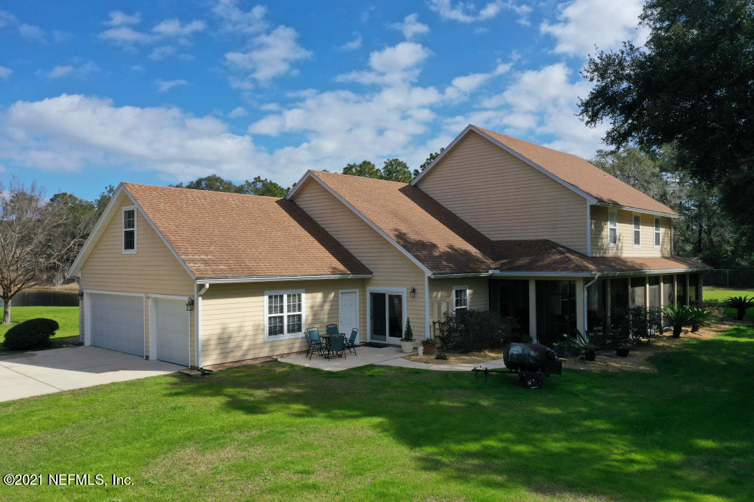 97002 Po Folks Way Yulee, FL 32097 - Photo 2 of 57 a front view of a house with a garden and porch