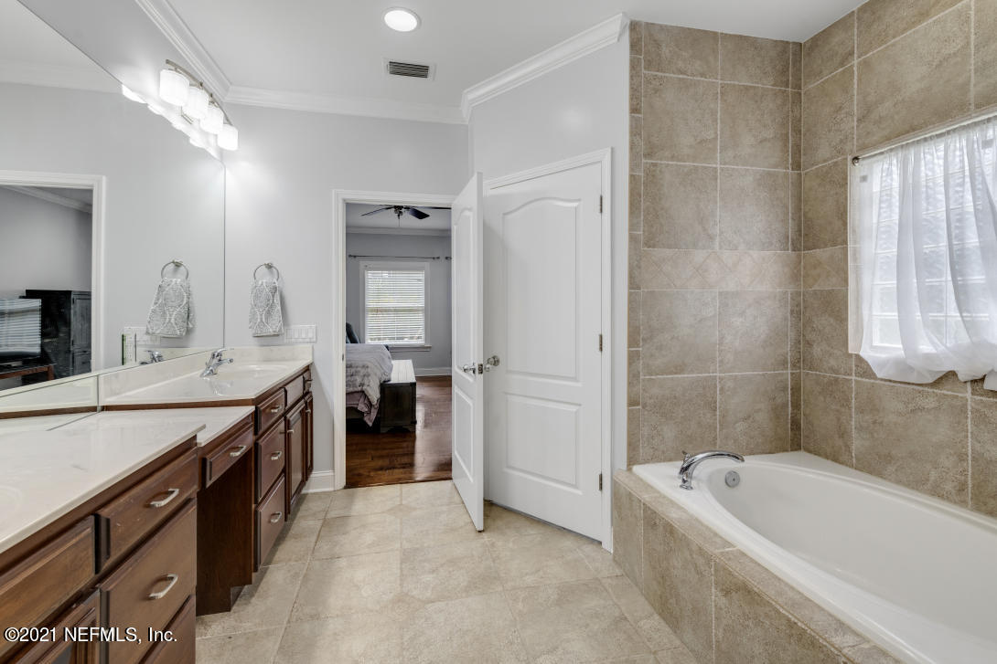 97002 Po Folks Way Yulee, FL 32097 - Photo 48 of 57 a spacious bathroom with a tub sink shower and mirror