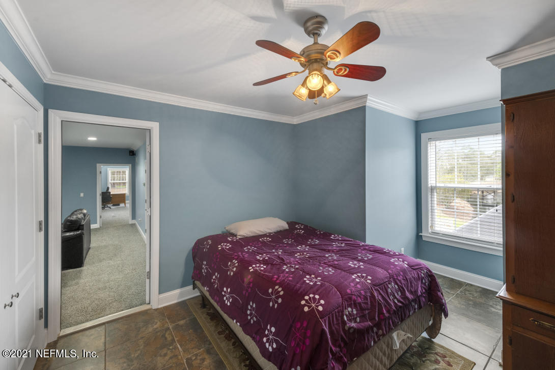 97002 Po Folks Way Yulee, FL 32097 - Photo 49 of 57 a bedroom with a bed and a chandelier