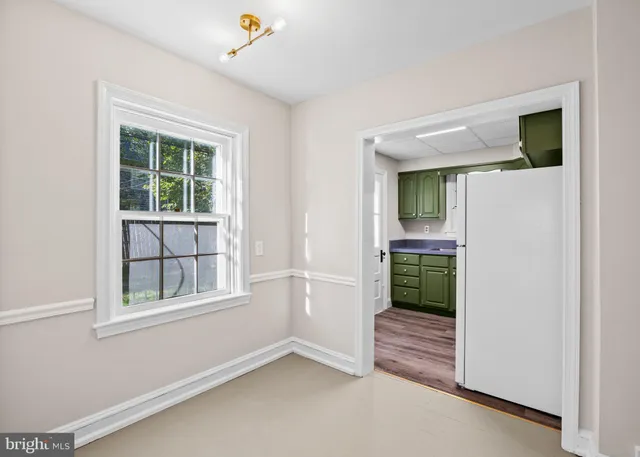 a view of kitchen with granite countertop cabinets and refrigerator