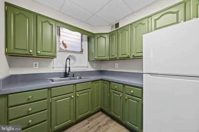 a kitchen with cabinets a refrigerator and a sink