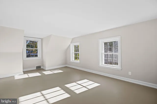 a view of utility room with baby crib and wooden floor