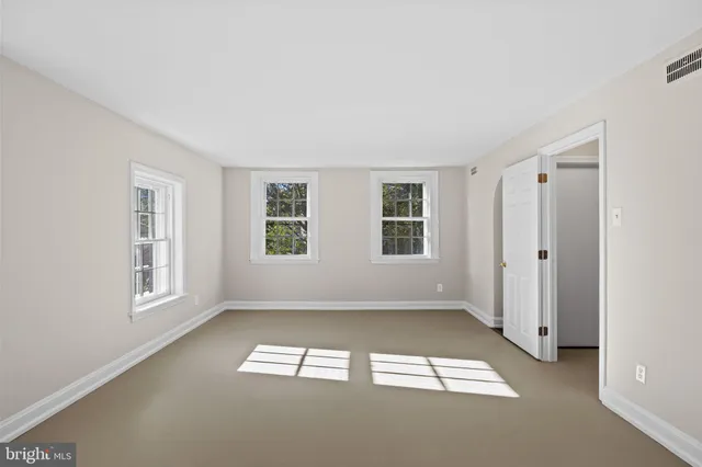 a view of hallway with window and wooden floor