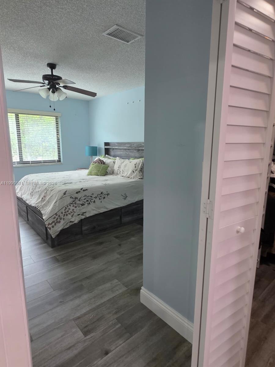 893 Southwest 120th Way Davie, FL 33325 - Photo 14 of 22 a bedroom with a bed and wooden floor