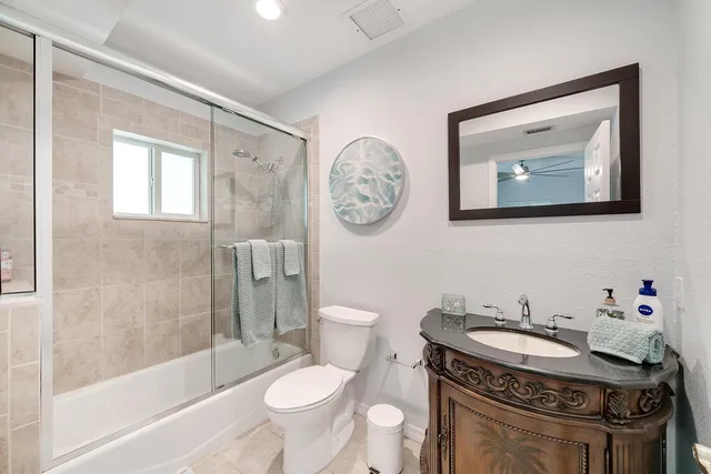 a bathroom with a granite countertop toilet a sink and a bathtub