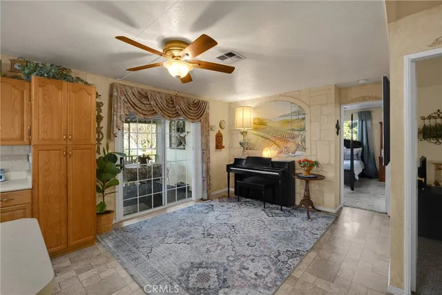 a view of a livingroom with a chandelier fan and windows