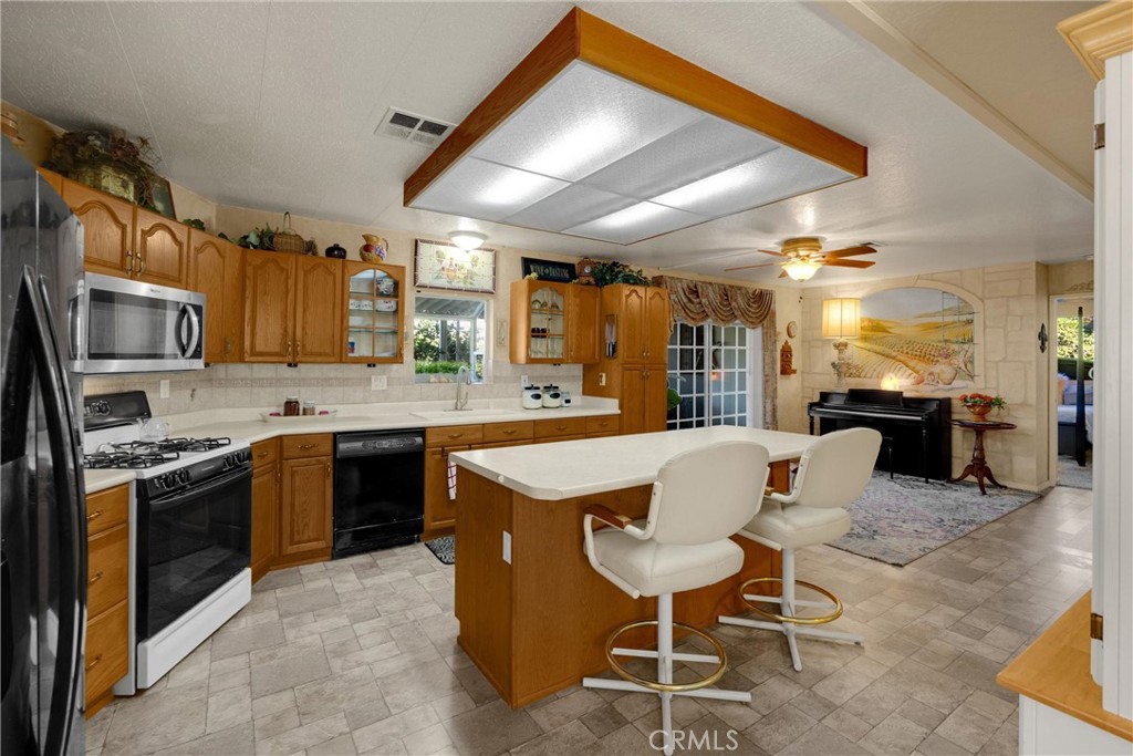10210 Base Line Road, Unit 235 Rancho Cucamonga, CA 91701 - Photo 13 of 33 a kitchen with a table chairs microwave and cabinets