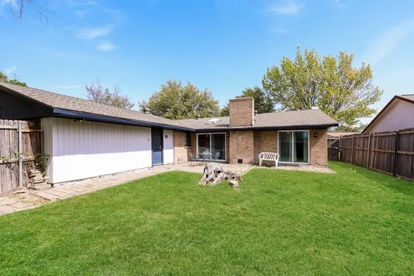 a backyard of a house with table and chairs