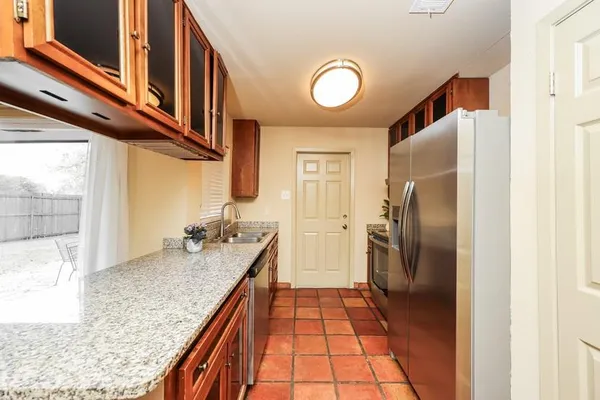 a kitchen with stainless steel appliances granite countertop a sink and a refrigerator