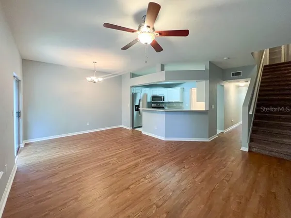 a view of a kitchen with wooden floor and a ceiling fan