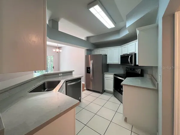 a kitchen with a sink a stove top oven and stainless steel appliances