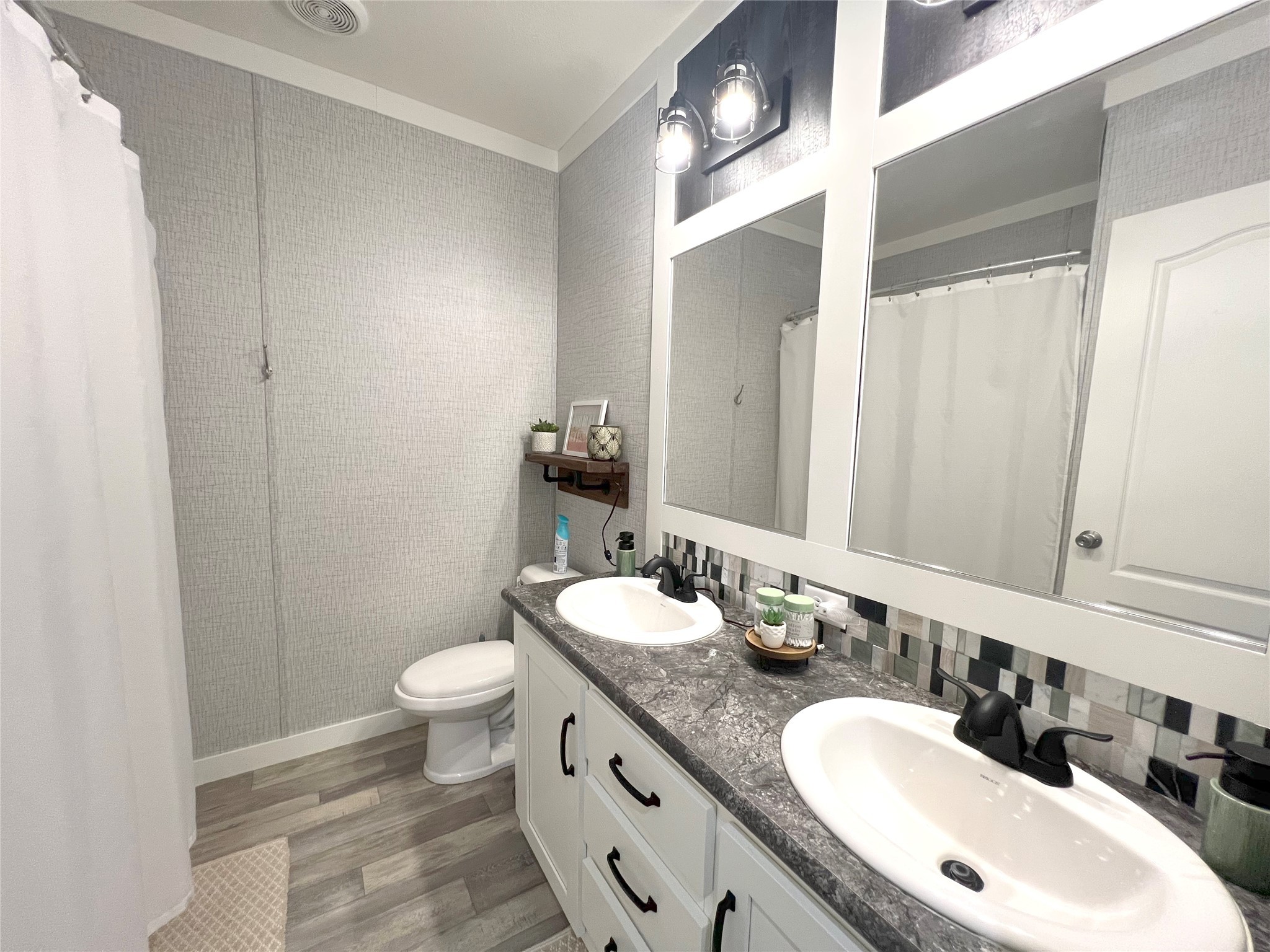 7391 FM 2546 Road El Campo, TX 77437 - Photo 27 of 50 a bathroom with a granite countertop double vanity sink a mirror and a toilet