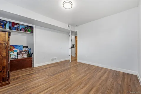 an empty room with wooden floor and closet