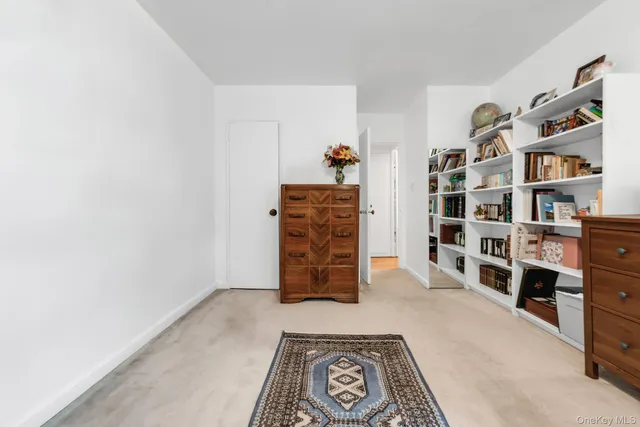a bedroom with a bed table chair and a window