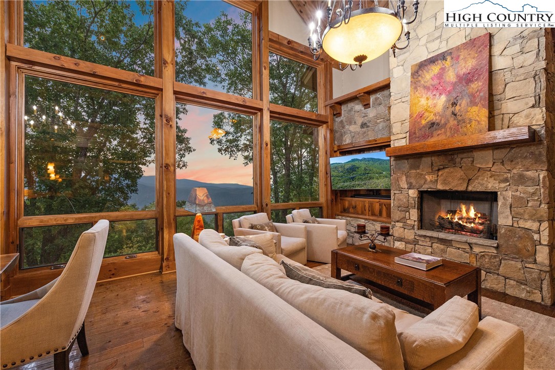 a living room with furniture a fireplace and a floor to ceiling window