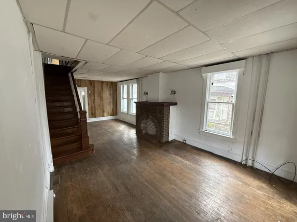 a view of a livingroom with a fireplace wooden floor and window