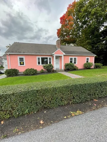 a front view of a house with a garden and trees