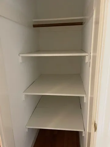 a view of a livingroom with wooden floor and a fireplace