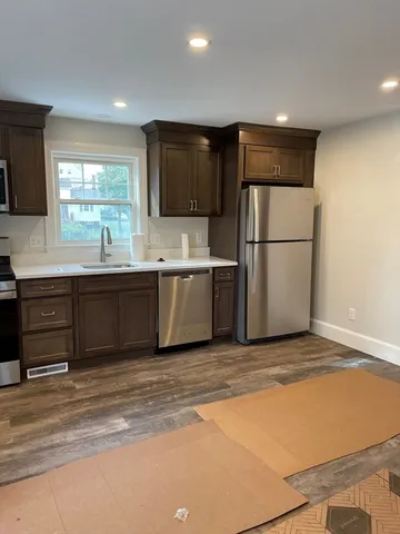 a kitchen with stainless steel appliances granite countertop a stove top oven a sink and a microwave