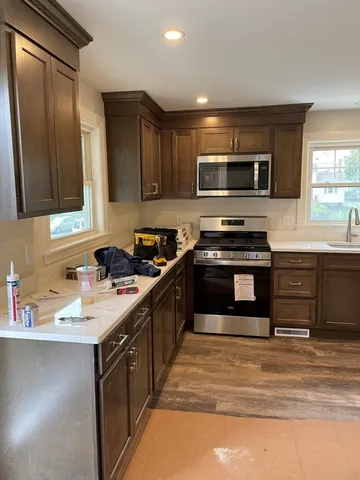a kitchen with stainless steel appliances granite countertop a sink and a stove