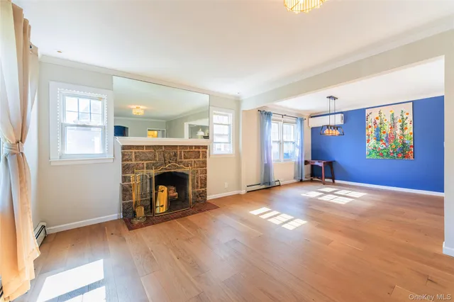 a view of empty room with fireplace and wooden floor
