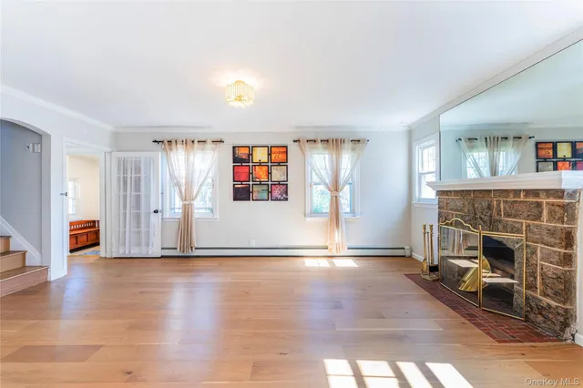 a view of empty room with wooden floor and fireplace