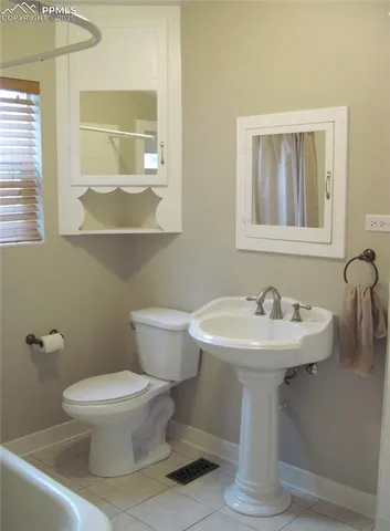a bathroom with a sink toilet and mirror