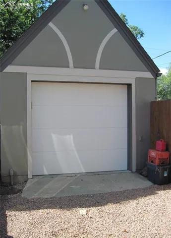 a view of a backyard with large trees and wooden fence