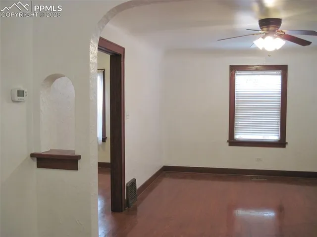 an empty room with chandelier fan