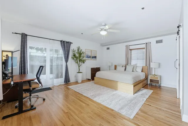 a bedroom with a bed and wooden floor