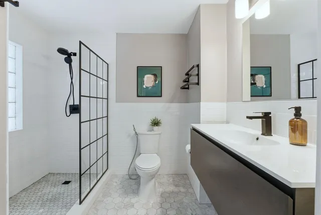 a bathroom with a sink a toilet and shower