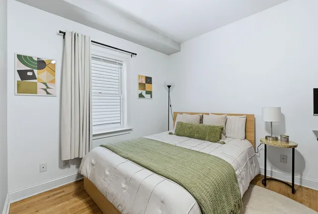 a bedroom with a bed and painting on the wall