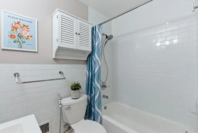 a bathroom with a toilet and a shower