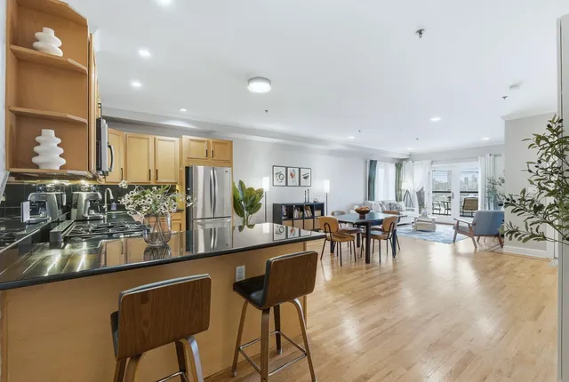 a kitchen with lots of counter and chairs