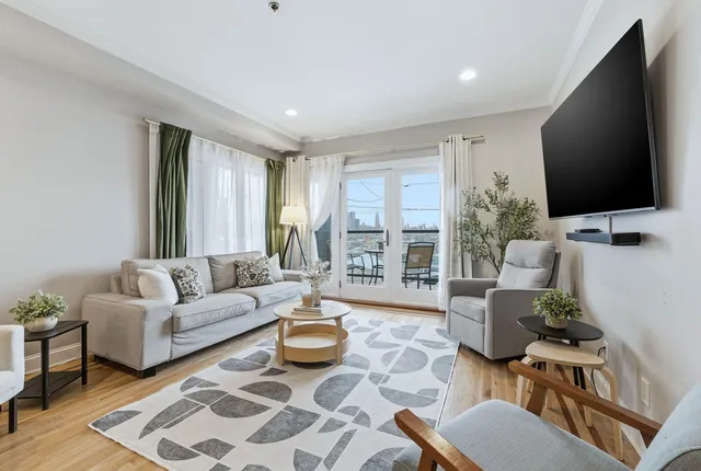 a living room with furniture flat screen tv and a large window