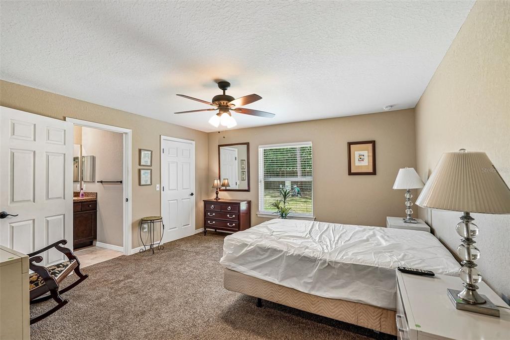 72 Cedar Road Ocala, FL 34472 - Photo 11 of 20 a bedroom with a large bed and a chandelier