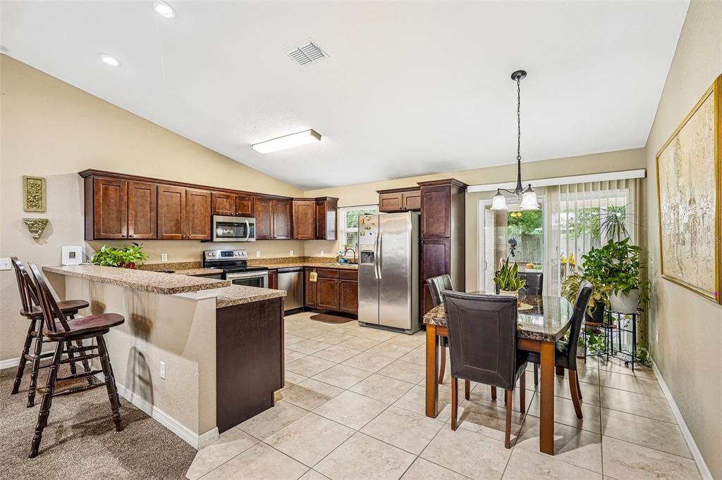 72 Cedar Road Ocala, FL 34472 - Photo 8 of 20 a kitchen with a table chairs refrigerator and microwave