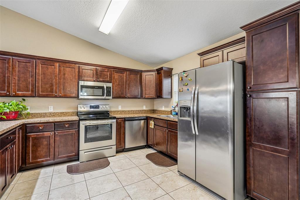 72 Cedar Road Ocala, FL 34472 - Photo 9 of 20 a kitchen with stainless steel appliances granite countertop a refrigerator sink and cabinets