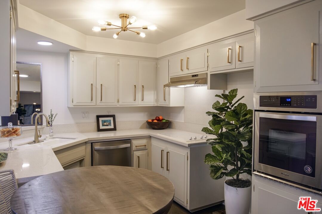 a kitchen with a white cabinets and potted plant