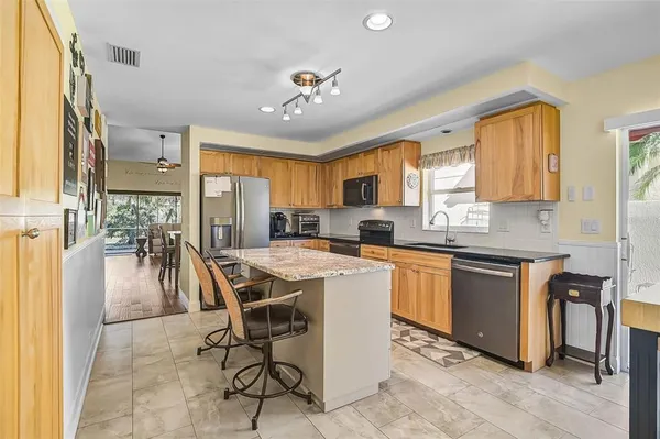 a kitchen with a table chairs refrigerator and cabinets