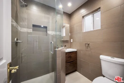 a bathroom with a sink a toilet and shower
