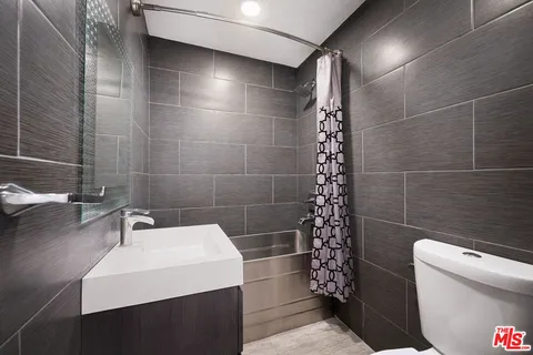 a patio with table and chairs and potted plants